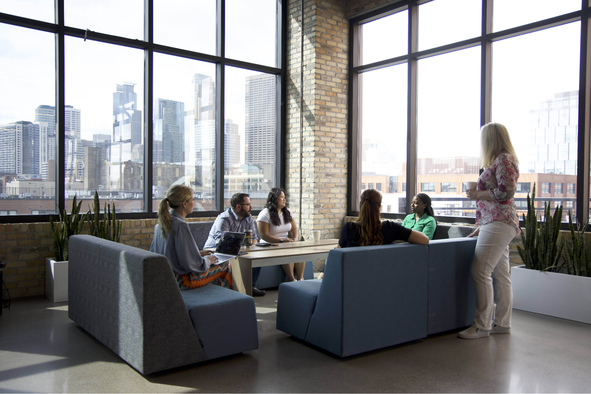 A team working and talking with a city skyline in the background